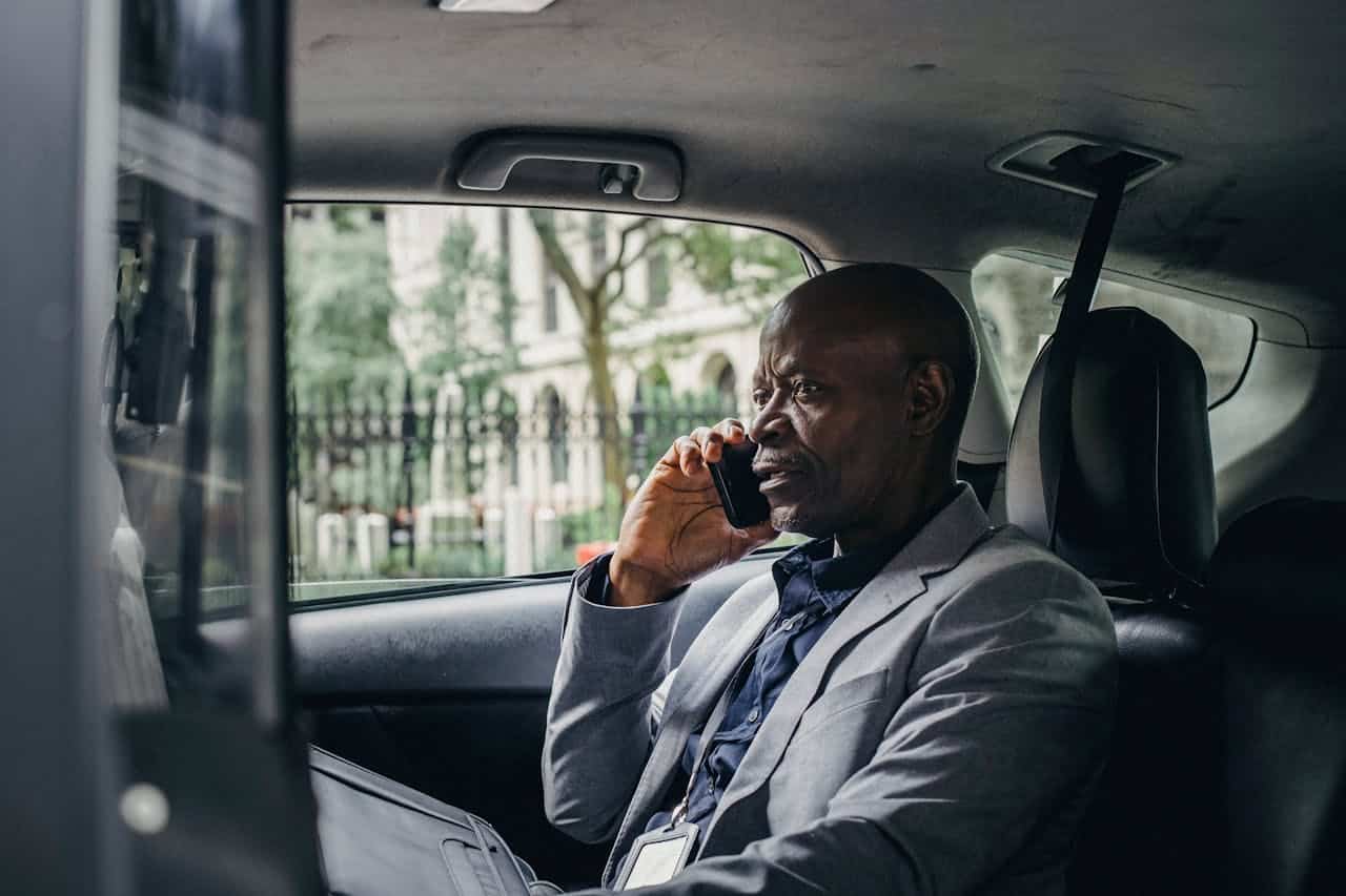 Pasajero hablando por teléfono en el asiento trasero de un taxi